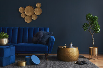 Elegant modern living room interior design with glamour blue velvet sofa, pouf, golden metal side...