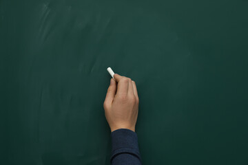 Naklejka premium Man with white chalk near green board, closeup. Space for text