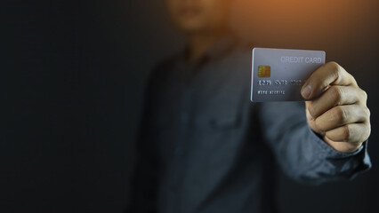 A man holding a credit card in his hand represents a fast pace of spending in the technology age and is convenient for the service user or the payer. Smart banking concept.