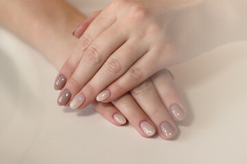 Obraz na płótnie Canvas close-up tenderness neutral beige manicure with glitter two hands