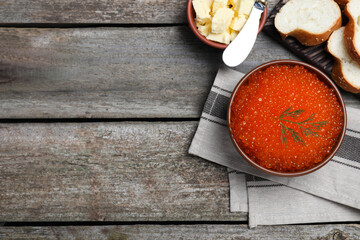 Flat lay composition with delicious red caviar on wooden table. Space for text