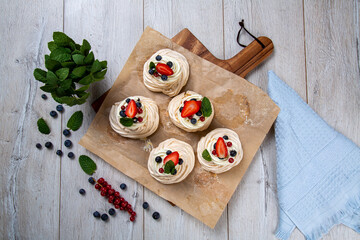 Meringue dessert garnished with forest fruits and strawberries. Meringue is a type of foam cookie...