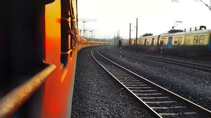 Beautiful morning image of two Indian train with rail between them in yellowish morning light and a bit fogg. Perfect image show Indian railways system. 