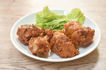 spicy crispy fried chicken drum wing with lemon leaf sauce and vegetable on plate