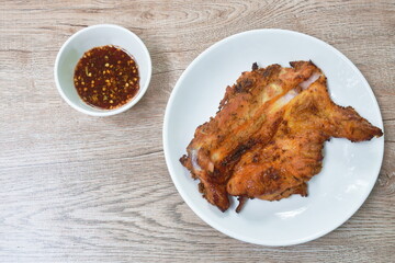 grilled chicken tight on plate dipping with spicy sauce