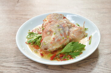 steamed mango fish head with chili and lemon dressings celery on plate