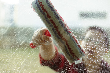 Woman cleaning glass doors and windows 