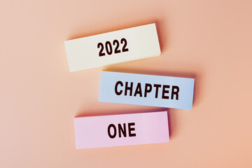 2022 chapter one. Concept of text on color cards. Top view image of cards and on pastel beige background. Flat lay design