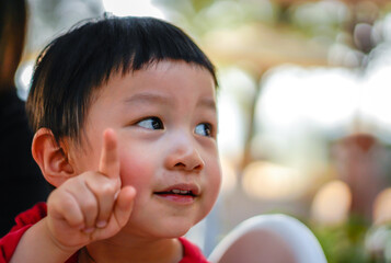 Cute little child thinking, close up, Selective focus, Blurred Background. Portrait of Cute kid thinking at the park.