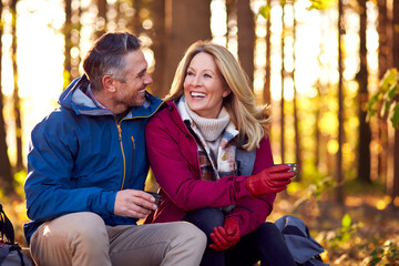 Mature Retired Couple Stop For Rest And Hot Drink On Walk Through Fall Or Winter Countryside