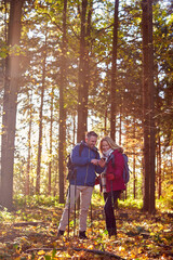 Mature Retired Couple Walk In Fall Or Winter Countryside Using Map Or Navigation App On Mobile Phone