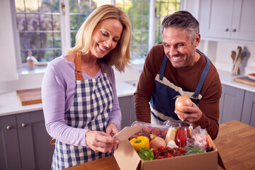 Mature Couple Unpacking Online Meal Food Recipe Kit Delivered To Home - obrazy, fototapety, plakaty