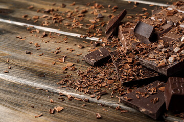 Grated chocolate and pieces of tasty chocolate on table