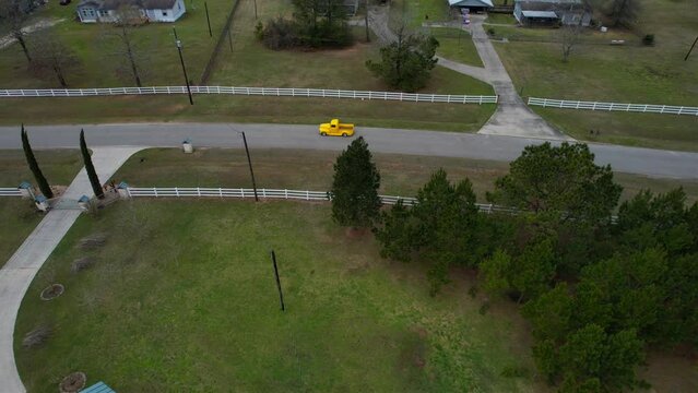 Aerial, driving through a neighborhood in a classic yellow pickup truck