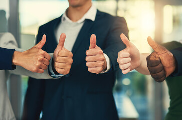 Youre our most valued employee. Cropped shot of a group of businesspeople giving thumbs up in a...