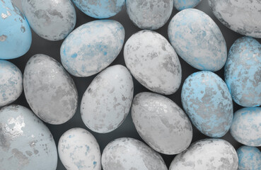 Light Blue, White and Gray Decorative Eggs with Silver Spots Lying in a Gray Background. Modern Easter Holiday Composition with Spotted Eggs. Top-Down View.