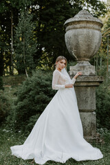 Beautiful stylish bride posing near old castle wall