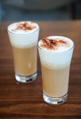 Zwei mit Kakao Pulver bestreute Gläser mit Kaffee Latte.