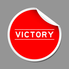 Red color peel sticker label with word victory on gray background