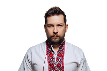 Half-length portrait of seriously looking man wearing ukrainian traditional cloth - embroidery shirt isolated over white studio background