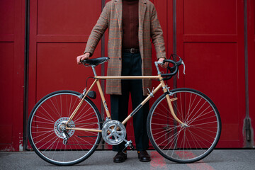 Young businessman with bike over red wall background in a city. Red color background