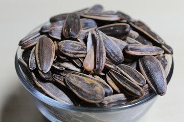 Pile of sunflower seed on a small bowl. Sunflower seed with striped shell.