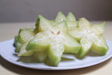 Carambola, or star fruit or 5 fingers, is the fruit of Averrhoa carambola. Green-yellow color. Cut in slices.