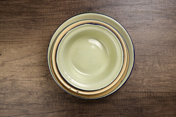 Enamel tin metal food plate pot bowl retro vintage tableware dinnerware on rustic wood background...