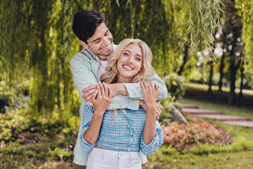 Naklejka na ściany i meble Portrait of two attractive cheerful sweet couple hugging spending time daydream honey moon on fresh air outdoors