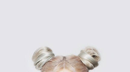 Close-up of two blonde hair buns. Copy space concept.