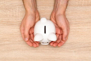 Human Hands Protecting Piggy Bank