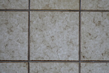 Close up: Beige tile wall, grey cement filling gaps, German 70s design, texture, copy space, background concept: vintage, retro, childhood memory (horizontal), Dahlbruch, NRW, Germany