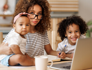Young irritated African-American mother freelancer trying to work while working remotely with kids