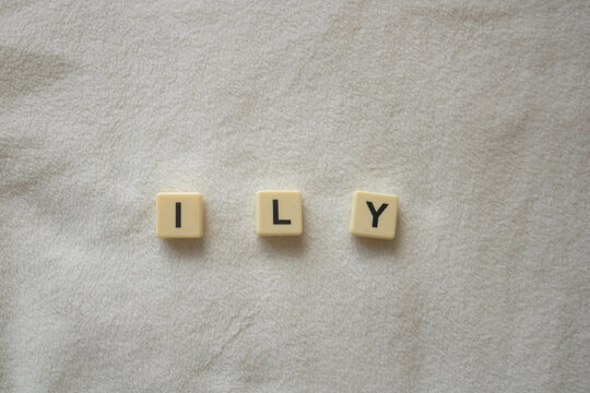 ILY written with scrabble / bananagram block letters on soft white fleece background, I love you, text language