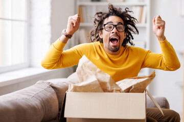 African American man cheering about delivered parcel