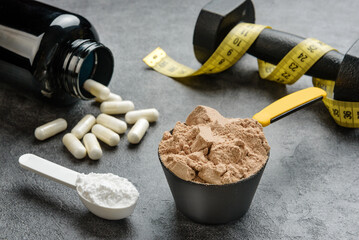 Scoops with protein and creatine close-up. The concept of sports nutrition and supplements. - obrazy, fototapety, plakaty