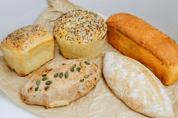 There are a lot of kinds of bread on the table.