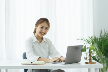 Charming asian businesswoman sitting working on laptop in office.