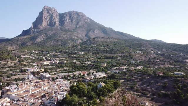 Aerial view of Finestrat village church on Puig Campana mountain background. Dolly in shot.