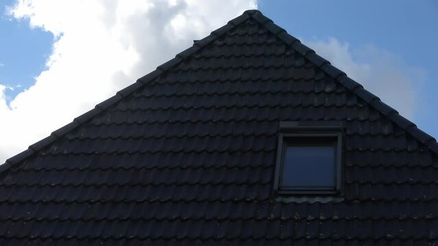 Time lapse of a roof window in velux style with black roof tiles.