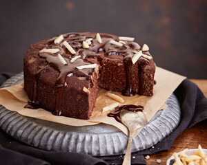 Healthy chocolate cake with almonds non sugar on a plate on the old wooden background. Selective focus. Keto diet.