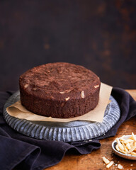 Healthy chocolate cake with almonds non sugar on a plate on the old wooden background. Selective focus. Keto diet.
