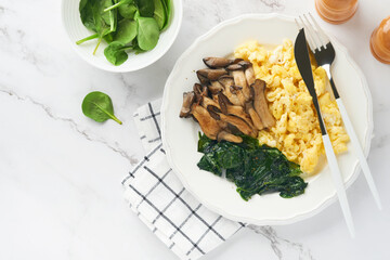 Omelet. Spinach oyster mushroom and cheese omelet or frittata on white marble background. Breakfast idea. Top view with copy space.