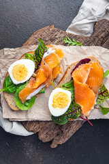 sandwich salmon smorrebrod egg, green salad mix, cereal bread toast seafood open fresh portion meal food snack on the table copy space food background 