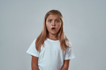 Fototapeta premium Front view of frightened girl looking at camera