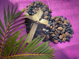 Lent Season,Holy Week and Good Friday concepts - image of cross made of palm leaf and crown of thorns on stones in purple vintage background. Stock photo.
