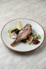 Plain roasted pike perch with lemon and salad on stone light plate, directly above view for menu