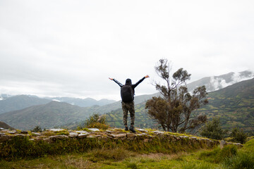 Mujer joven turista con mochila mirando el paisaje, Perú sobre hermosos acantilados de fondo. Viajes, estilo de vida activo y concepto de vacaciones de invierno.