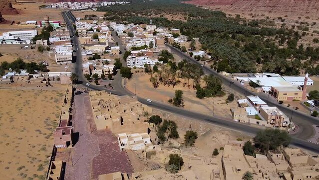 Aerial view overlooking traffic in a modern town, in Al Ula, Saudi Arabia - tracking, drone shot