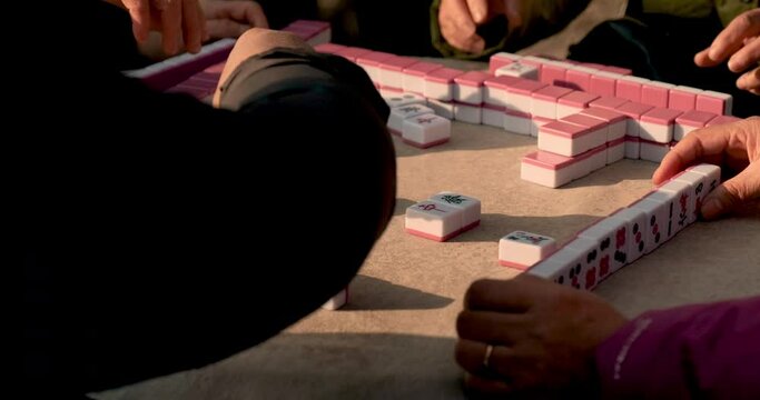 Chinese people playing Mahjong board game in Shanghai People Square